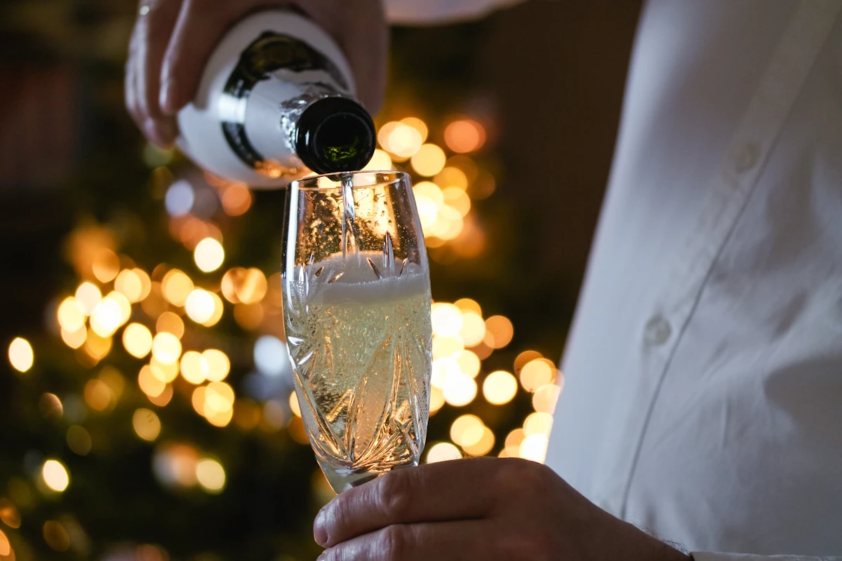 Une personne qui sert un verre de champagne blanc de blancs