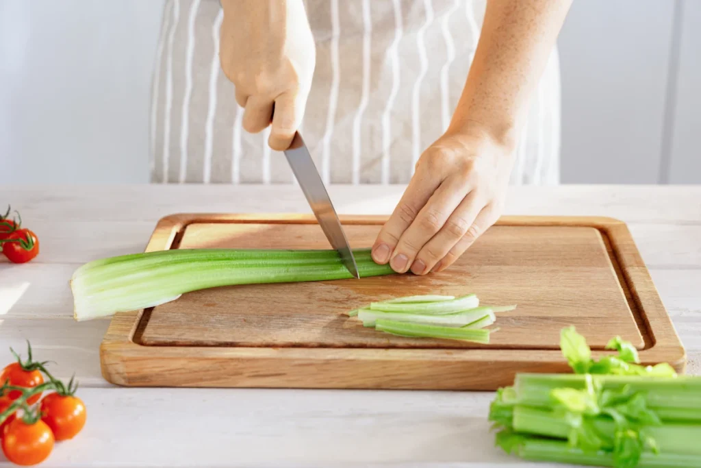 Une femme qui utilise le céleri branche dans sa préparation