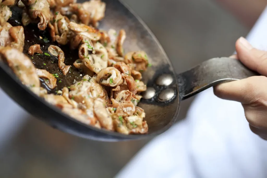 Une personne qui cuisine de la seiche