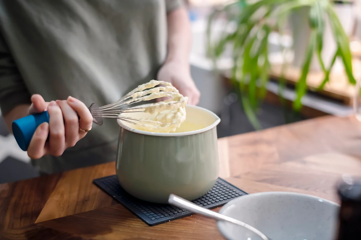 Une personne qui fouette de la crème anglaise
