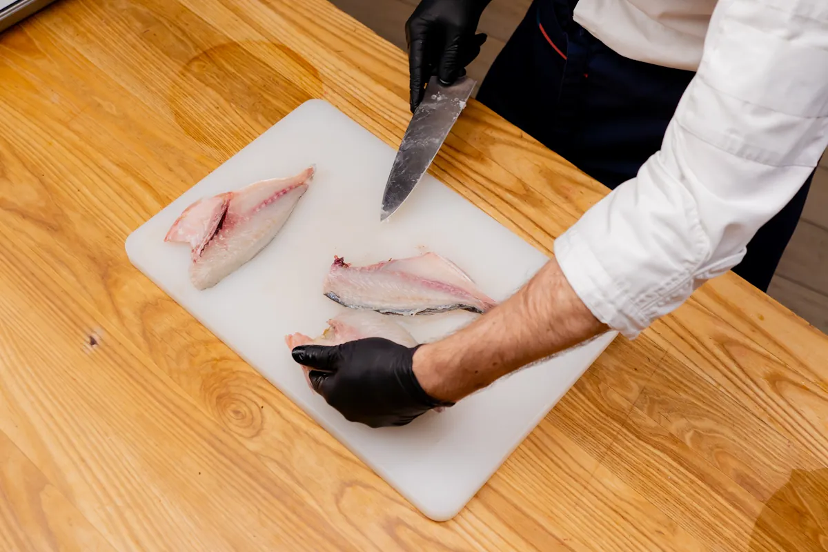 Une personne qui prépare et découpe le congre avant cuisson