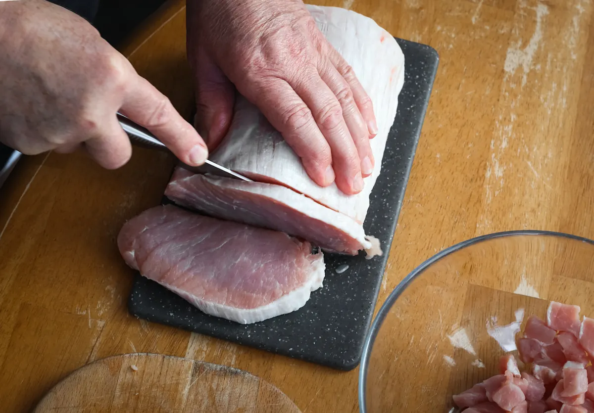 Une personne qui prépare de la viande de porc