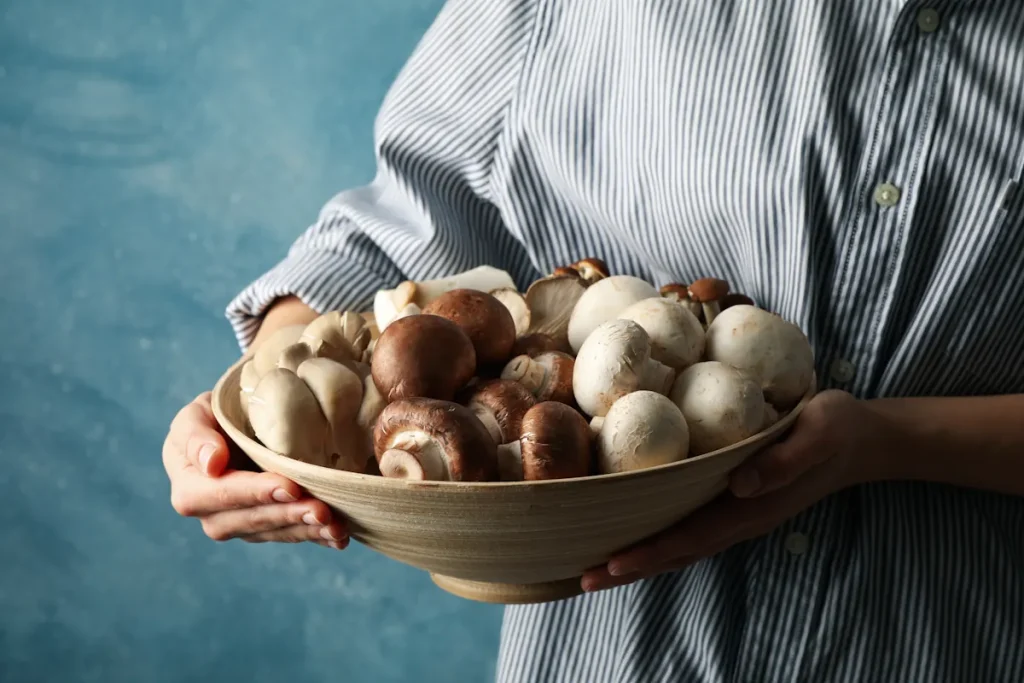 Une personne qui tient une assiette de champignons frais
