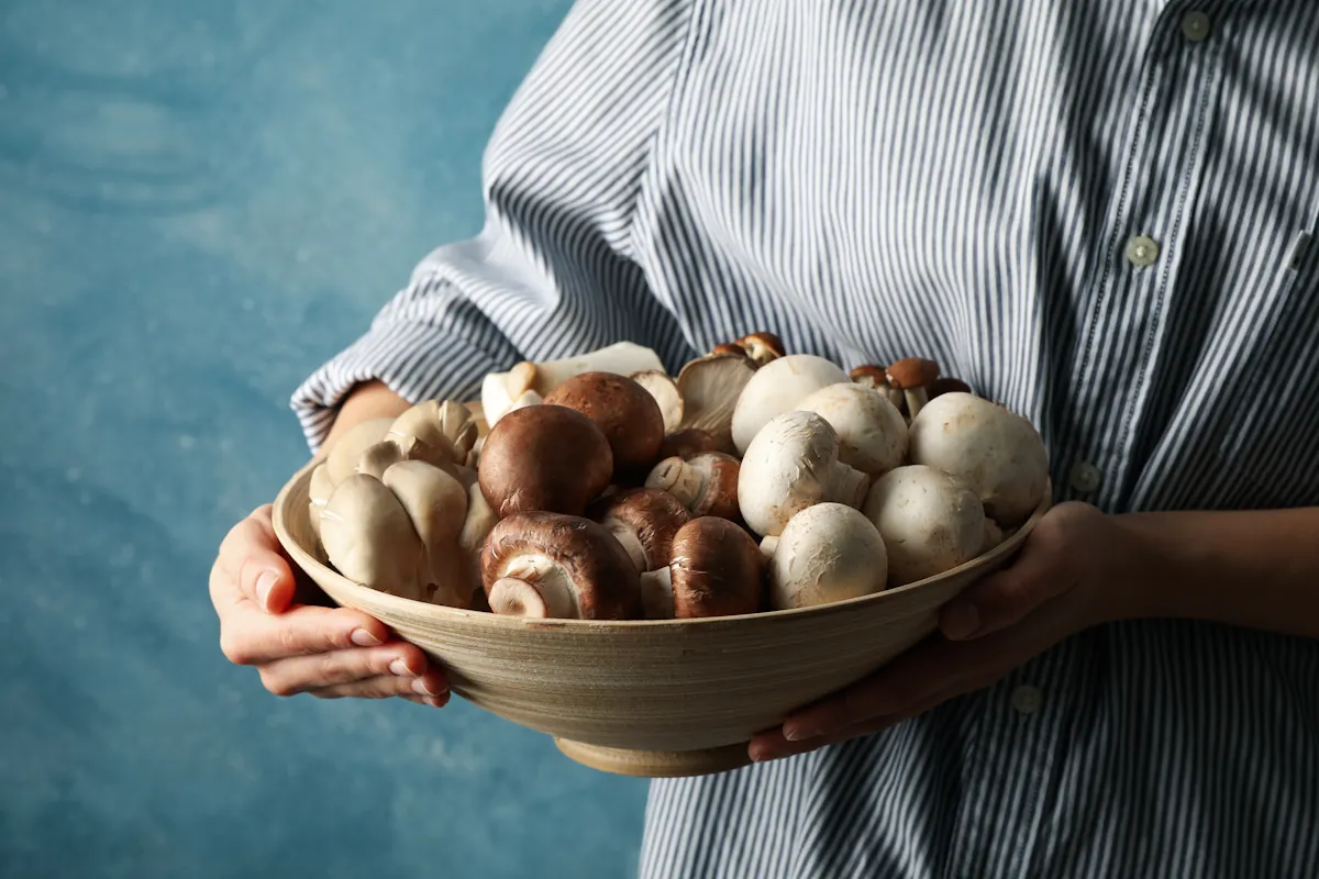 Une personne qui tient une assiette de champignons frais