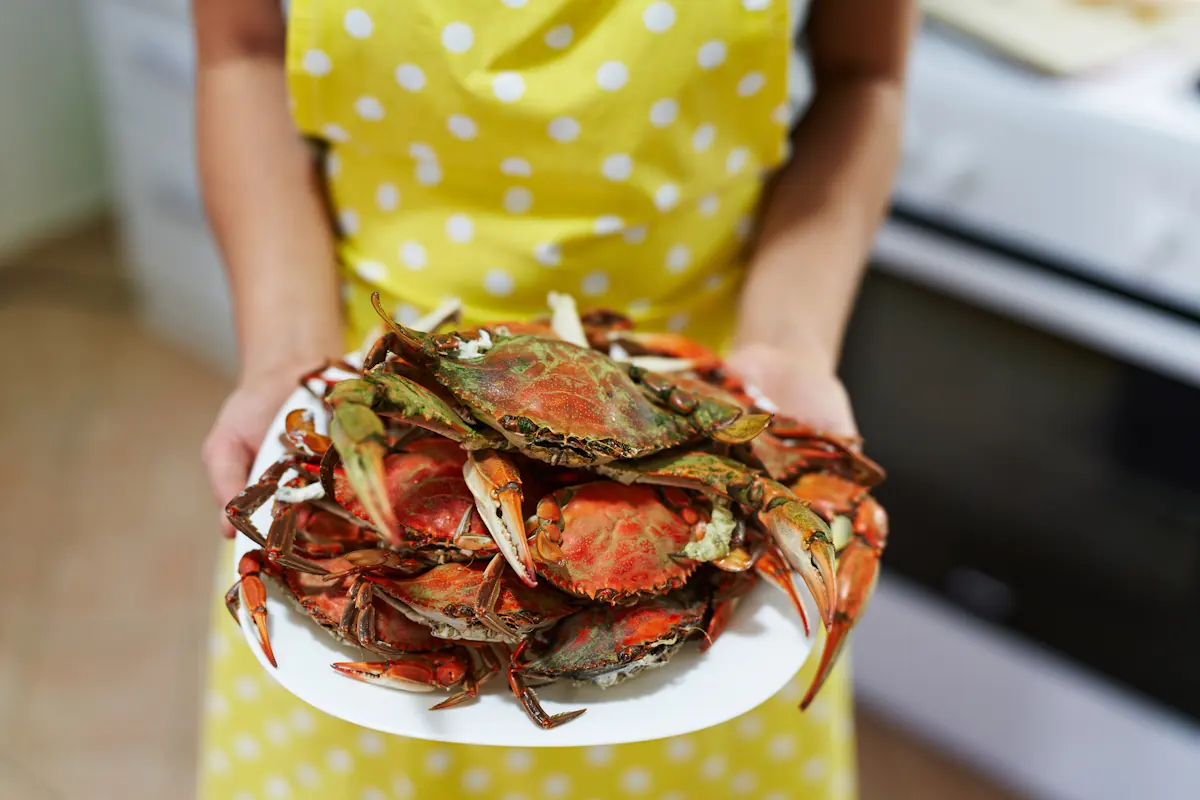 Une femme qui tient un plat de tourteau cuit