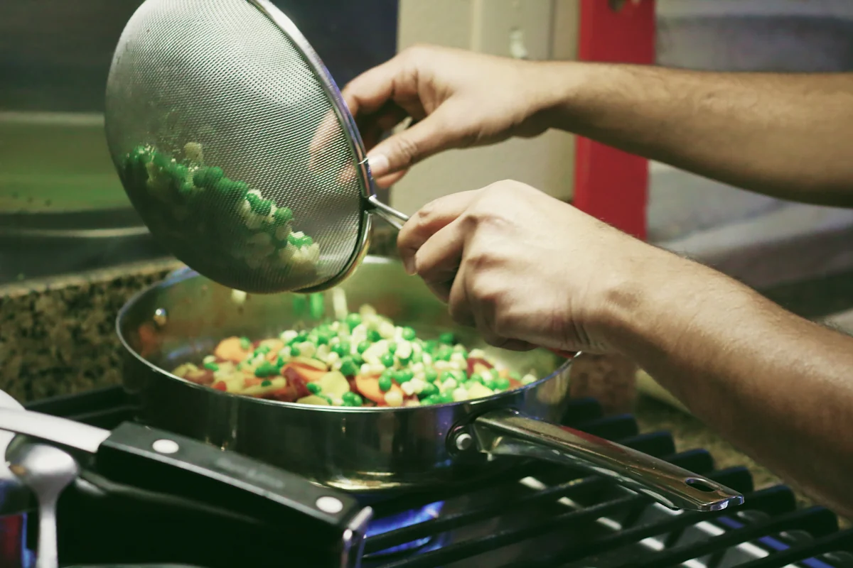 Une personne qui cuisine un plat de petit pois carotte