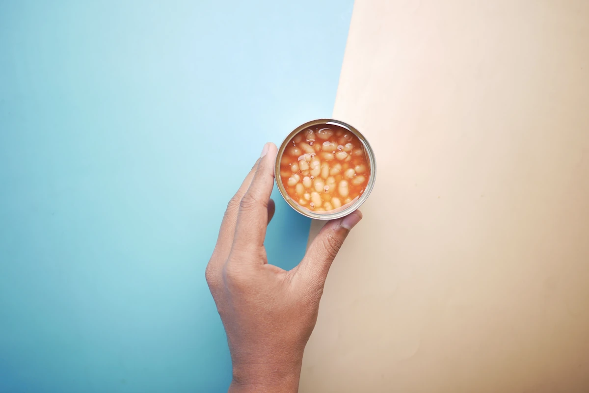 Une main qui tient des flageolets en boîte
