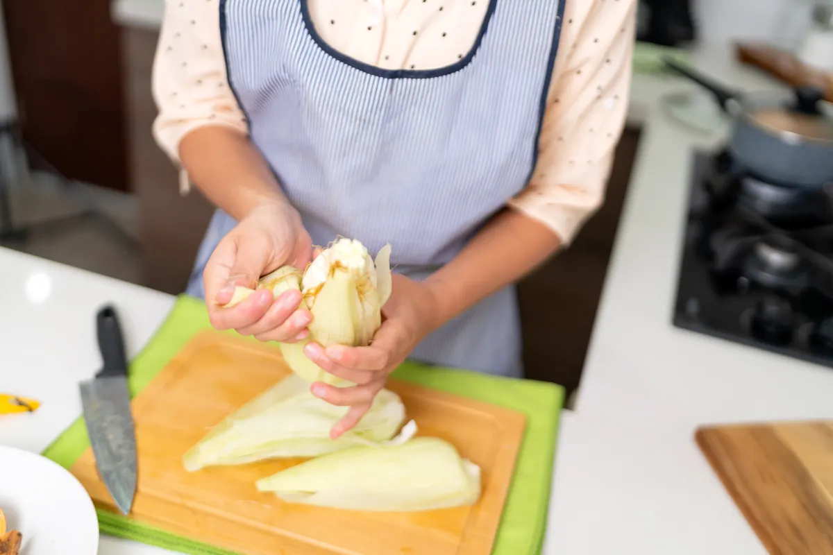 Une femme qui prépare des endives braisées