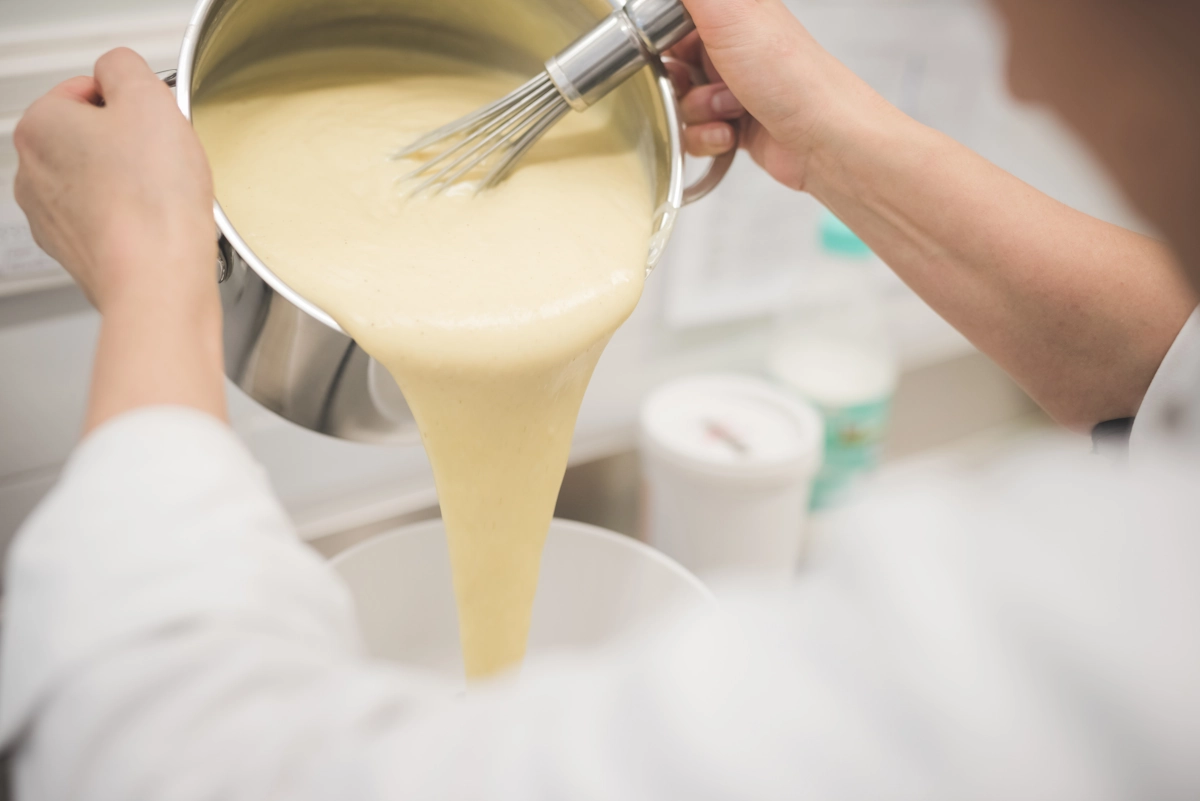Une personne qui prépare la crème anglaise