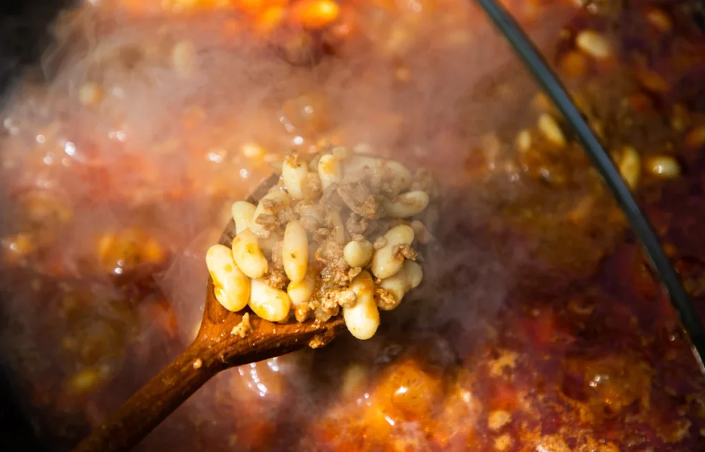 Une personne qui cuit des flageolets en boite