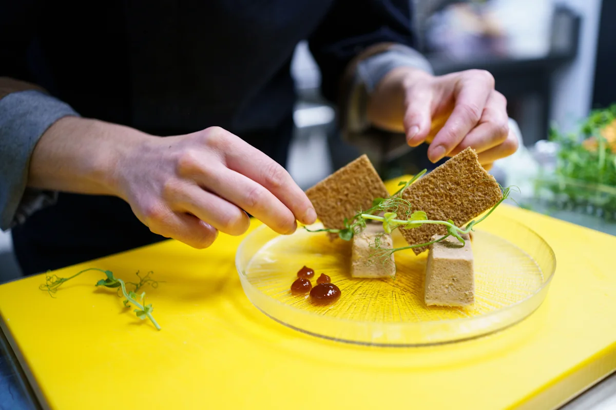 Une personne qui sert une assiette de terrine de poisson